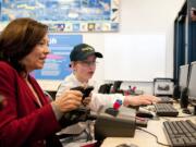 Pearson Air Museum volunteer Kaya Galbraith, 13, guides U.S. Sen. Maria Cantwell, D-Wash., on a simulated flight Tuesday from Portland International Airport to Troutdale, Ore. Cantwell visited the Vancouver museum for a discussion on how to maintain U.S.