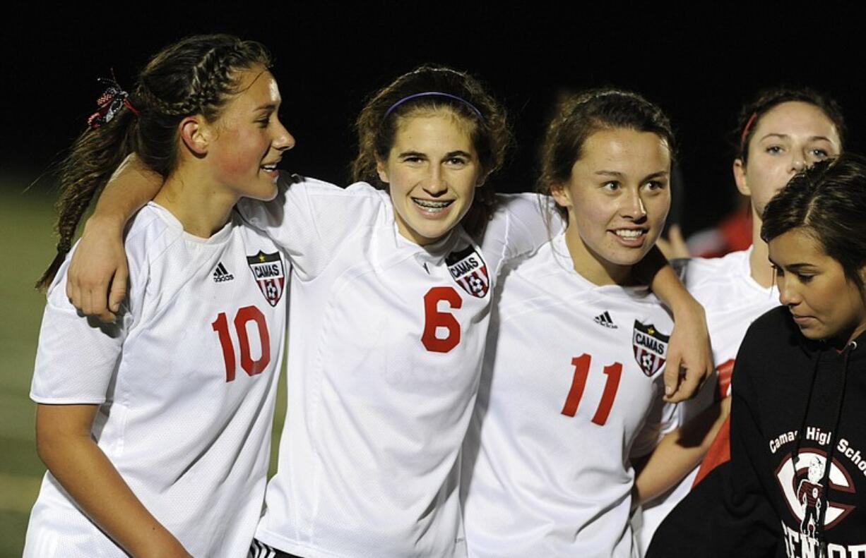 Camas players including Lauren Oljar (10), Alex Dombek (6) and Olivia Howell (11) celebrate their win over Kelso for the league title.