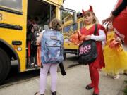 Cameryn Ramseyer, 6, a first-grade student, proves that even a devil has to wait to board the school bus on Halloween Monday afternoon at Hathaway Elementary School in Washougal.