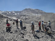 A group of journalists and other hikers stand near the rim of Mount St. Helens' crater recently. The Mount St.