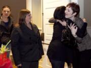 Renee Newman, right, director of retail banking, hugs a fellow co-worker from First Independent Bank at the employee goodbye party Wednesday evening at the Fort Vancouver Artillery Barracks.