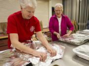 First United Methodist Church volunteers such as Joyce Gentry, left, and Gwyn Vollmer periodically cook and deliver free meals to hungry residents of Courtyard Village Apartments.