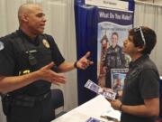 Sgt. Dave Henderson speaks with Frankie Cordova about job opportunities at Vancouver Police Department at a recent Hispanic Job Fair in Portland.