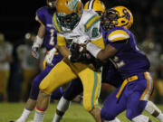 Columbia River's Nathan Hawthorne, right, brings down Tumwater running back Dominic Jones.