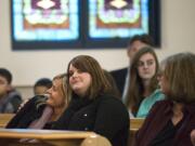 Andrea Bannister of Vancouver, center, a survivor of the 1999 Columbine High School shooting, and her sister, Sabrena Jackson of Camas, embrace during a Sunday ceremony against gun violence at St. Paul Lutheran Church in Vancouver.