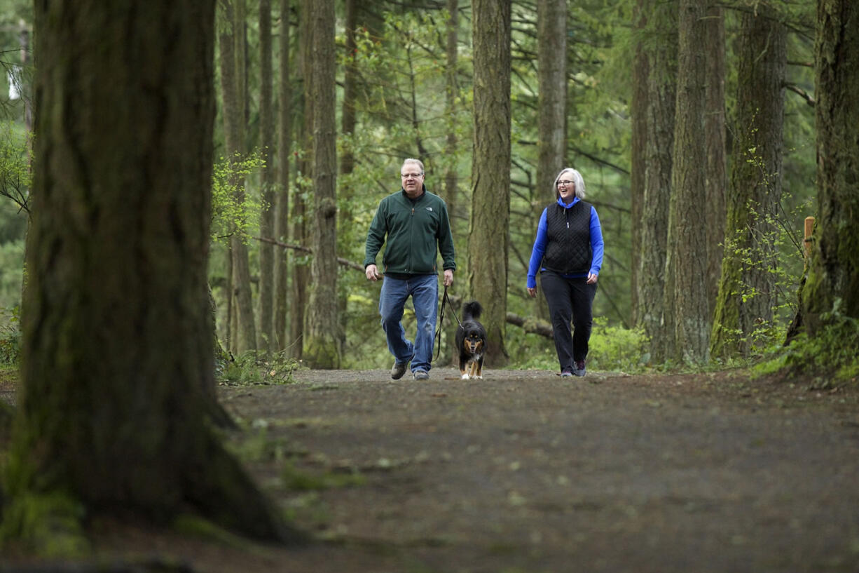 Camas residents Helen and Jay Elder, and their dog, Wesley, walk the trails along Round Lake on Wednesday.