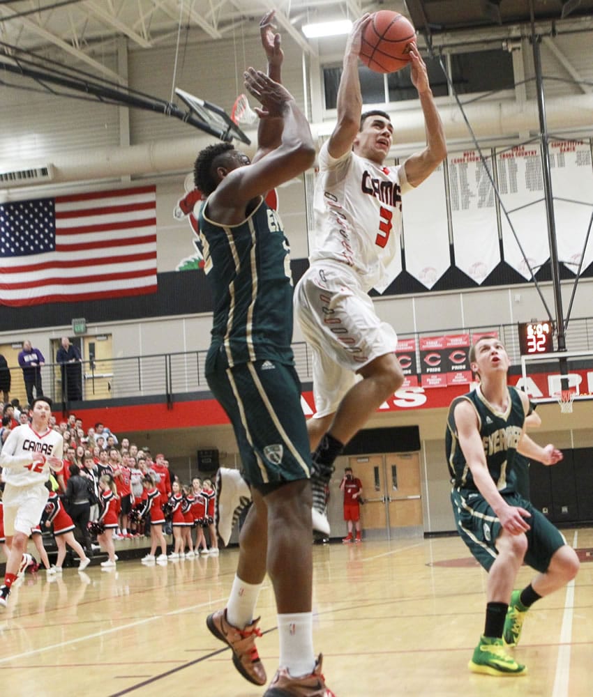 Camas High School player Andre De Los Rios shoots the ball as Evergreen High School player Robert Franks tries to block him during Friday's 4A GSHL game at Camas.