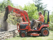 Rick Dobson uses a tractor to work in his yard at his home in Kalama.