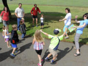 Participants warm up before a StoryWalk session led by Three Creeks librarian Barbara Jorgenson, right, and youth librarian Heather Rhone, second from right, Monday at H.B.