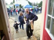 Charles Frost, right, leads his family, from left, Charles Deacon, 2, Michelle and 8-year-old Serenity (behind her dad) into their new home. Well-wishers had just given them the traditional housewarming gifts of bread, salt and wine.