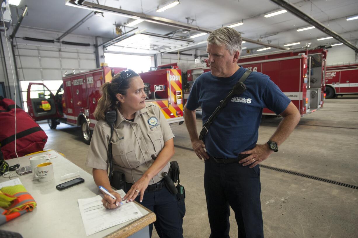 Clark County animal control officer Trisha Kraff collects information from firefighter Mike Hollingsworth about a kitten rescued Thursday from the electrical box of an RV.