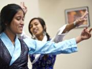 Nepalese visitors Manisha Sunuwar, 20, left, and Pooja Ghimire, 21, perform a traditional Nepalese dance at Shared Hope International on Friday.