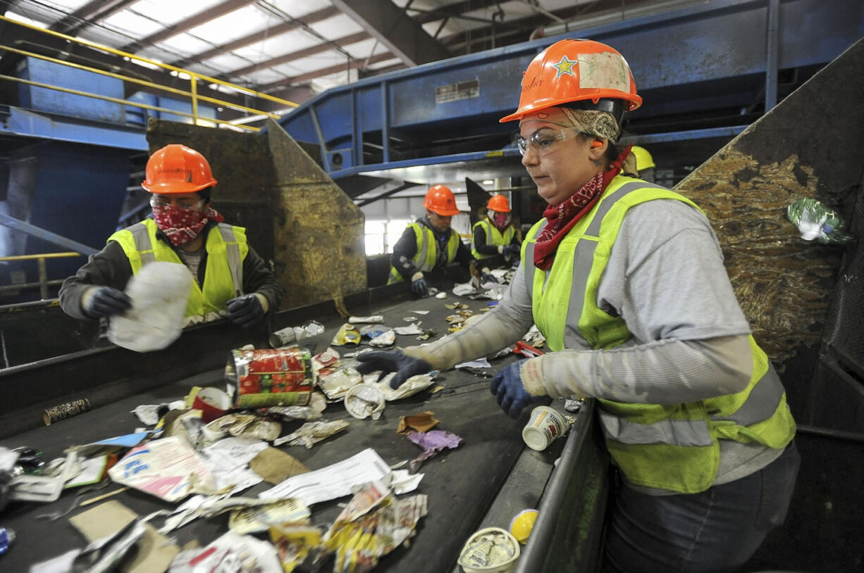 Workers separate recyclables on conveyor belts at the West Van Material Recovery Facility, where 35,000 tons of Clark County's recyclable material are processed each year.