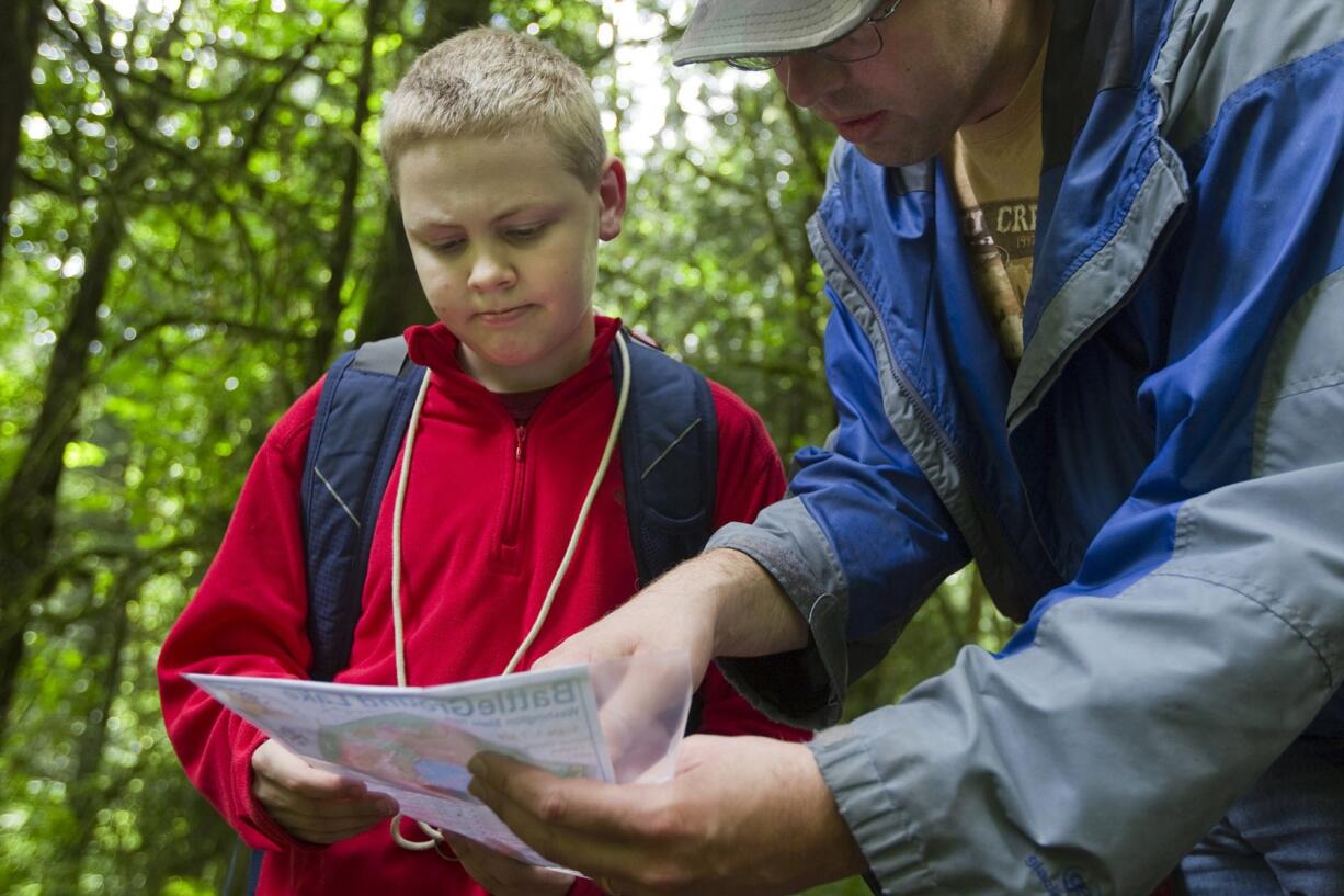 Lucas Carter, left, and Dan Weinmaster consult the map during Saturdayu2019s event organized by the Columbia River Orienteering Club at Battle Ground Lake State Park.