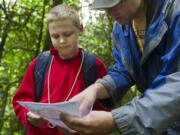 Lucas Carter, left, and Dan Weinmaster consult the map during Saturdayu2019s event organized by the Columbia River Orienteering Club at Battle Ground Lake State Park.