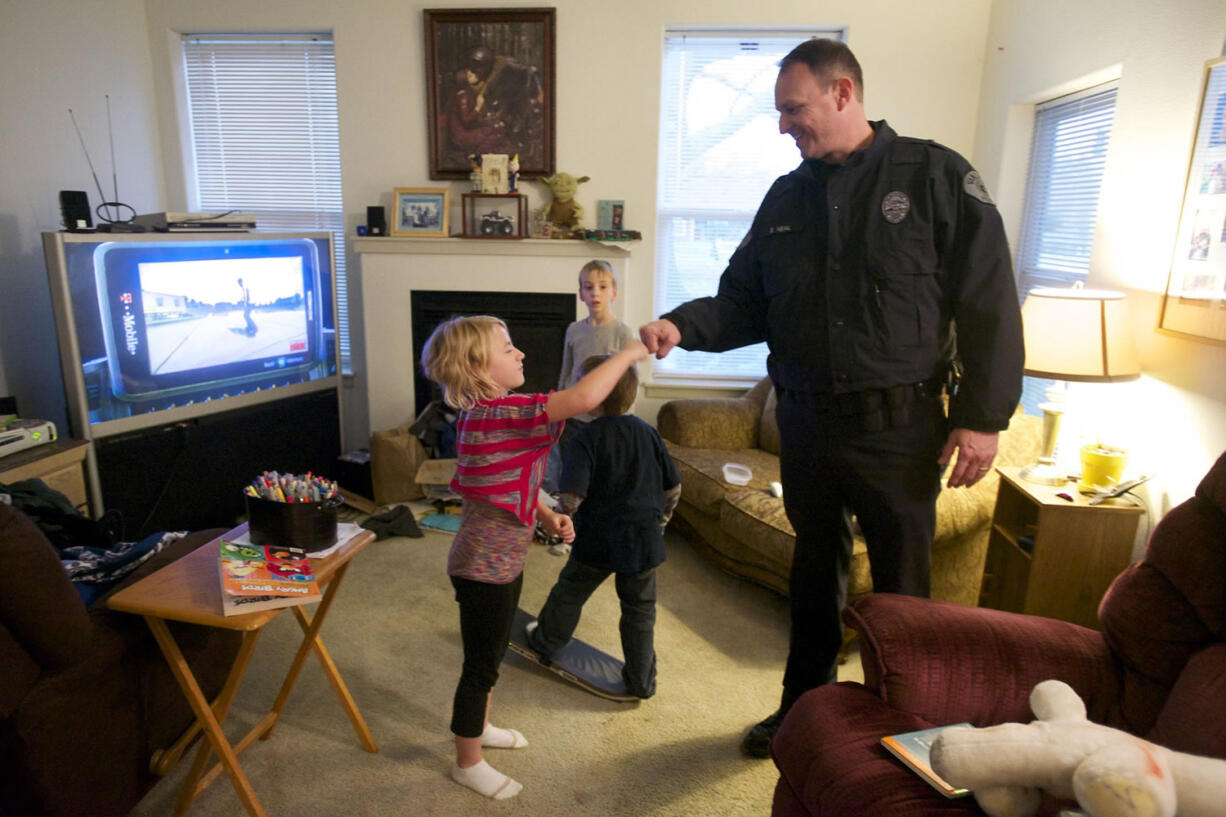 Lt. Steve Neal greets Lillie Killaby, 7, while delivering Thanksgiving food to her family. &quot;Do you arrest people?&quot; Killaby asked.