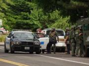 Officers from the Southwest Washington Regional SWAT Team take a man into custody after a four-hour standoff Saturday on East 18th Street in Vancouver. The man, whose name was not released Saturday, was wanted for violation of a restraining order and had a warrant related to a domestic violence incident.