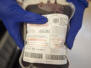 A technician holds a bag of fresh blood during Bloodworks Northwest’s community picnic and blood drive at the group’s Vancouver donation center in August 2015.