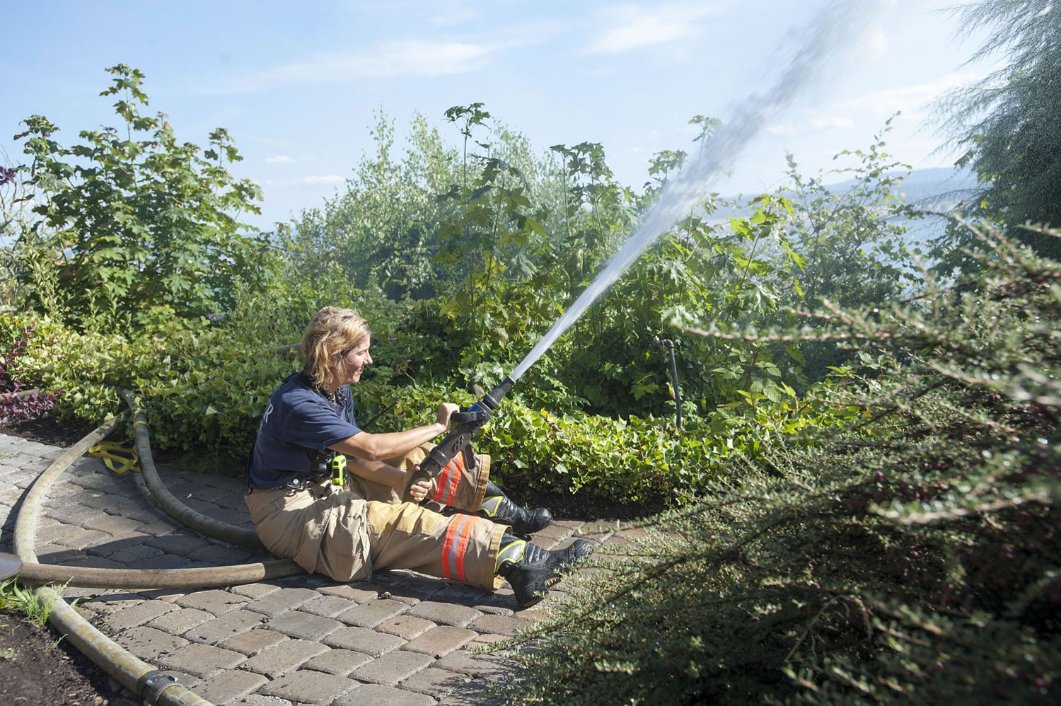 Firefighter Heidi Parr sprays down a hillside on Buena Vista Drive.