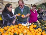 From left, Bonnie James, Matt James and Linda James select small pumpkins on sale Sunday, the last day of the Vancouver Farmers Market's 25th season.