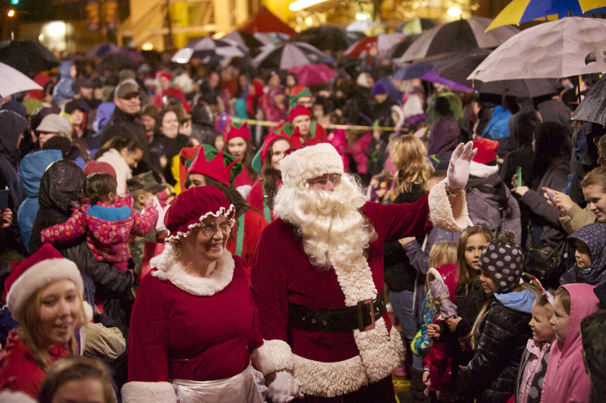 Photos by STEVEN LANE/The Columbian
Above, Santa and Mrs. Claus arrive at Esther Short Park on Friday for the annual Vancouver community Christmas tree lighting.