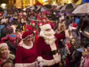 Photos by STEVEN LANE/The Columbian
Above, Santa and Mrs. Claus arrive at Esther Short Park on Friday for the annual Vancouver community Christmas tree lighting.