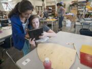 Savanna Falkner, a student at Vancouver School of Arts and Academics, uses an iPad earlier this month to show a classmate how she will paint a shield representing William de Lanvallei, an English baron during the 13th century.