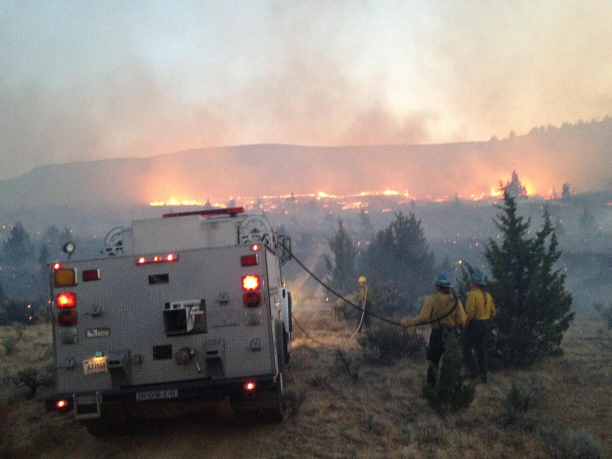 Firefighters prepare to drive into the fire area on a wildfire in 2012 near Madras.