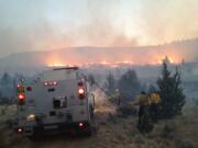 Firefighters prepare to drive into the fire area on a wildfire in 2012 near Madras.