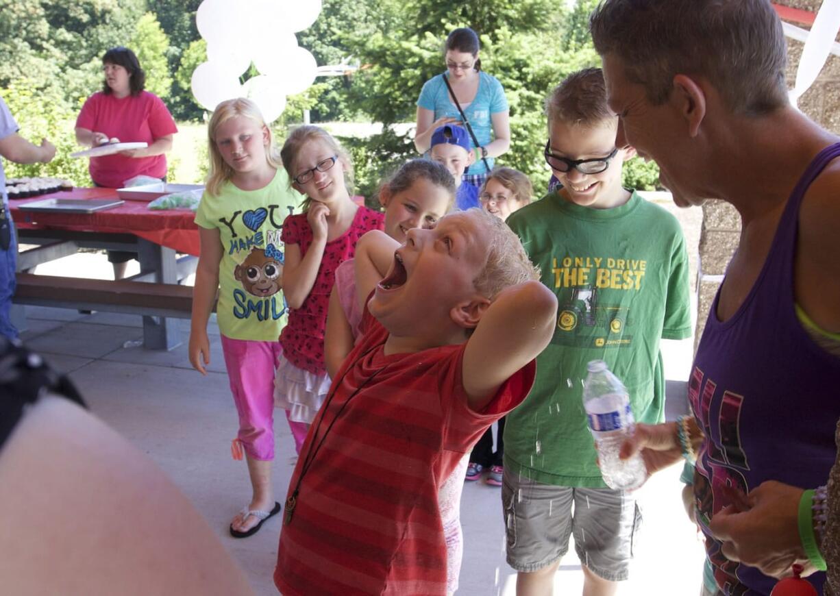 Jack Conover of Ridgefield center, is drenched with water by his grandma Tina Conover during his first Heart Day celebration Sunday afternoon at Fairgrounds Community Park. One year ago, Jack, now 8, received a heart transplant.