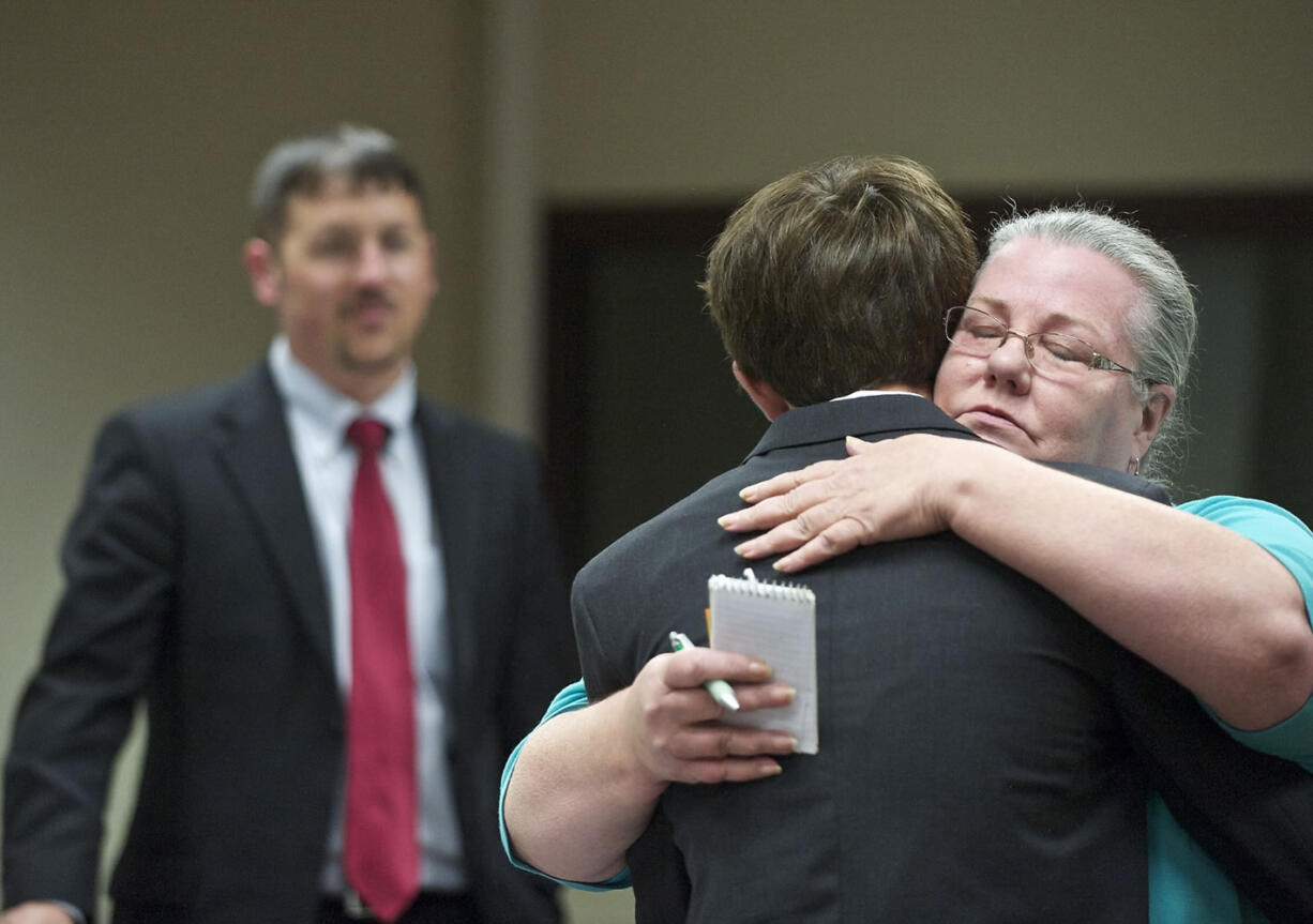 Crestline Elementary School third-grade teacher Audrey Christina hugs Dylan Mork, as Deputy Prosecutor Dan Gasperino looks on, Monday during his sentencing hearing for starting the fire that destroyed the school.