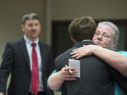 Crestline Elementary School third-grade teacher Audrey Christina hugs Dylan Mork, as Deputy Prosecutor Dan Gasperino looks on, Monday during his sentencing hearing for starting the fire that destroyed the school.