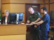 Clean energy entrepreneur John Garrett Smith is fingerprinted in Clark County Superior Court after being sentenced to 12 years in prison for the attempted murder of his wife.