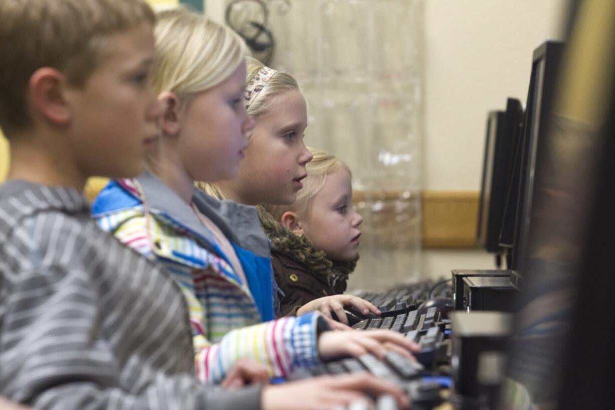 Homola siblings, from left: Jarett, 10; Janae, 8; Karly, 9, and Alexa, 6, practice math and reading skills on Jan.