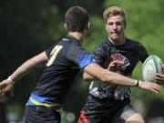 Brendon Curle of Union tries to thwart a Newberg player from gaining control of the ball in the Rugby Oregon Varsity Premiership state championship game in Portland on Saturday, May 30, 2015.