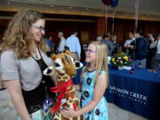 Kacia Gauthier, neonatal intensive care unit manager at Legacy Salmon Creek Medical Center, left, wishes Breanna Bullion of La Center a happy 10th birthday after presenting the girl with a stuffed giraffe from the hospital staff. Breanna was the first patient at the Salmon Creek hospital when it opened 10 years ago.