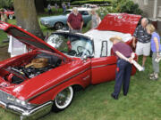 Visitors admire a 'Regal Red' 1960 Chrysler Crown Imperial owned by Joel Holland of Sumner, Wa, at the 2015 Concourse d'Elegance at Officers Row in the Fort Vancouver historic site in Vancouver  Wa., Sunday August 2, 2015.