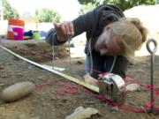 Photos by Paul Suarez/The Columbian
Jodi Marshall takes measurements to document where a wall stood at the Little Proulx dig at Fort Vancouver National Historic Site on Thursday.