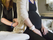 Doula Julia Schetky applies pressure to Brittany Lawrence's sacrum to help with contractions and back pain during labor.