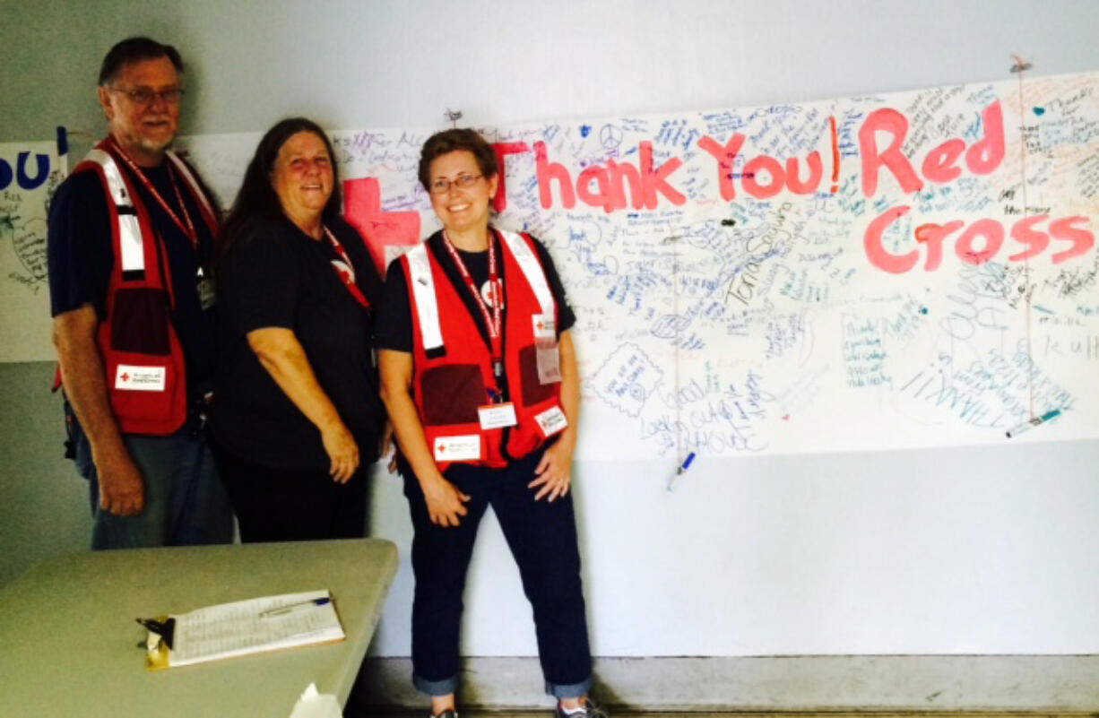 Vancouver Red Cross volunteers Richard Wing, Jannette Hube and Tammy Sullivan pose with thank-you messages at the Red Cross shelter in Warm Springs, Ore., in mid-August.