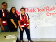 Vancouver Red Cross volunteers Richard Wing, Jannette Hube and Tammy Sullivan pose with thank-you messages at the Red Cross shelter in Warm Springs, Ore., in mid-August.