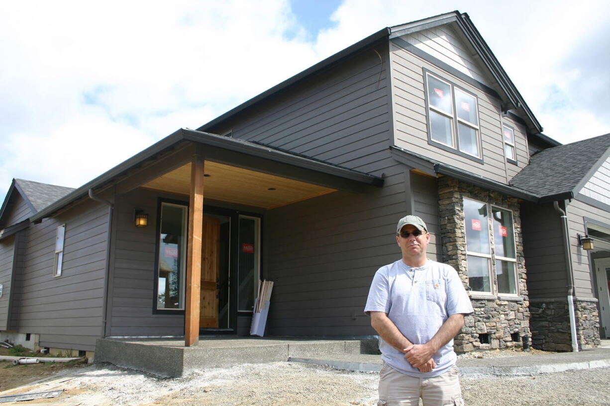 Eric Barnett, a pilot for United Airlines, spends his days off watching workers put the final touches on his new house in Ridgefield.