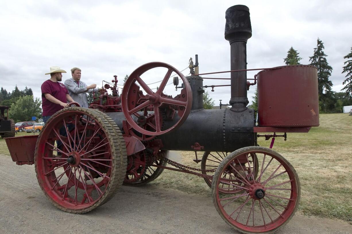 Lester Schurman, right, and Ben Scofield maneuver a 1910 Garscott 10 horsepower steam tractor through the grounds at the Rural Heritage Fair in Ridgefield in 2014.