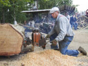 Charlie Davis uses a 1947 Mercury chainsaw at the Rural Heritage Fair in Ridgefield, Sunday July 20, 2014.  The event hosted by the Fort Vancouver Antique Equipment Association, showcases the tools used in Clark County during the 19th and 20th centuries.