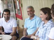 Kourosh Zamanizadeh, from left, and his parents, Mike and Rose Zamanizadeh, sit on the Skamania General Store's porch with store manager Michelle Sobaski, right.