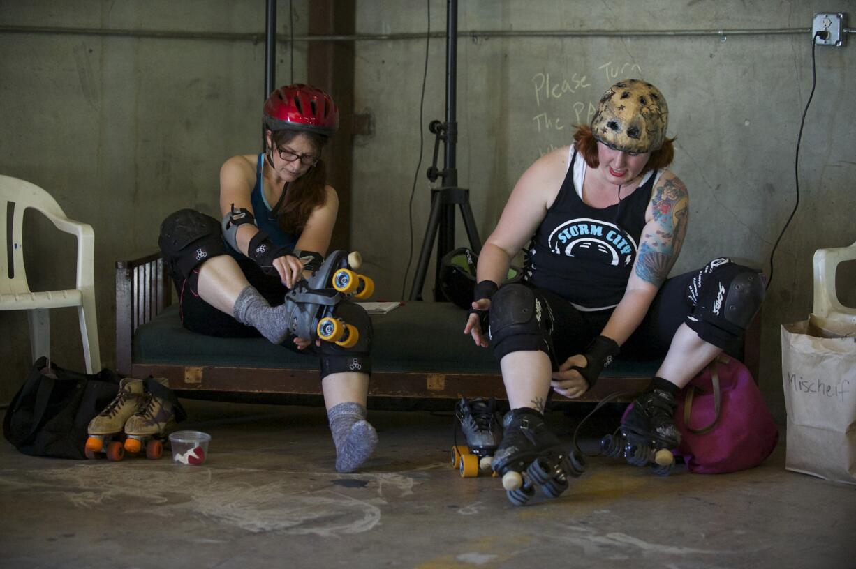 Columbian reporter Susan Parrish, left, &quot;Dragon Diva,&quot; and derby skater Mischief lace up skates to prepare for fresh meat tryouts for Storm City Roller Girls.