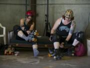 Columbian reporter Susan Parrish, left, &quot;Dragon Diva,&quot; and derby skater Mischief lace up skates to prepare for fresh meat tryouts for Storm City Roller Girls.