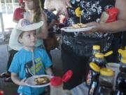 Dalton Anderson 4, watches as his grandma doles out syrup on their pancake breakfast at the Clark County Fairgrounds.