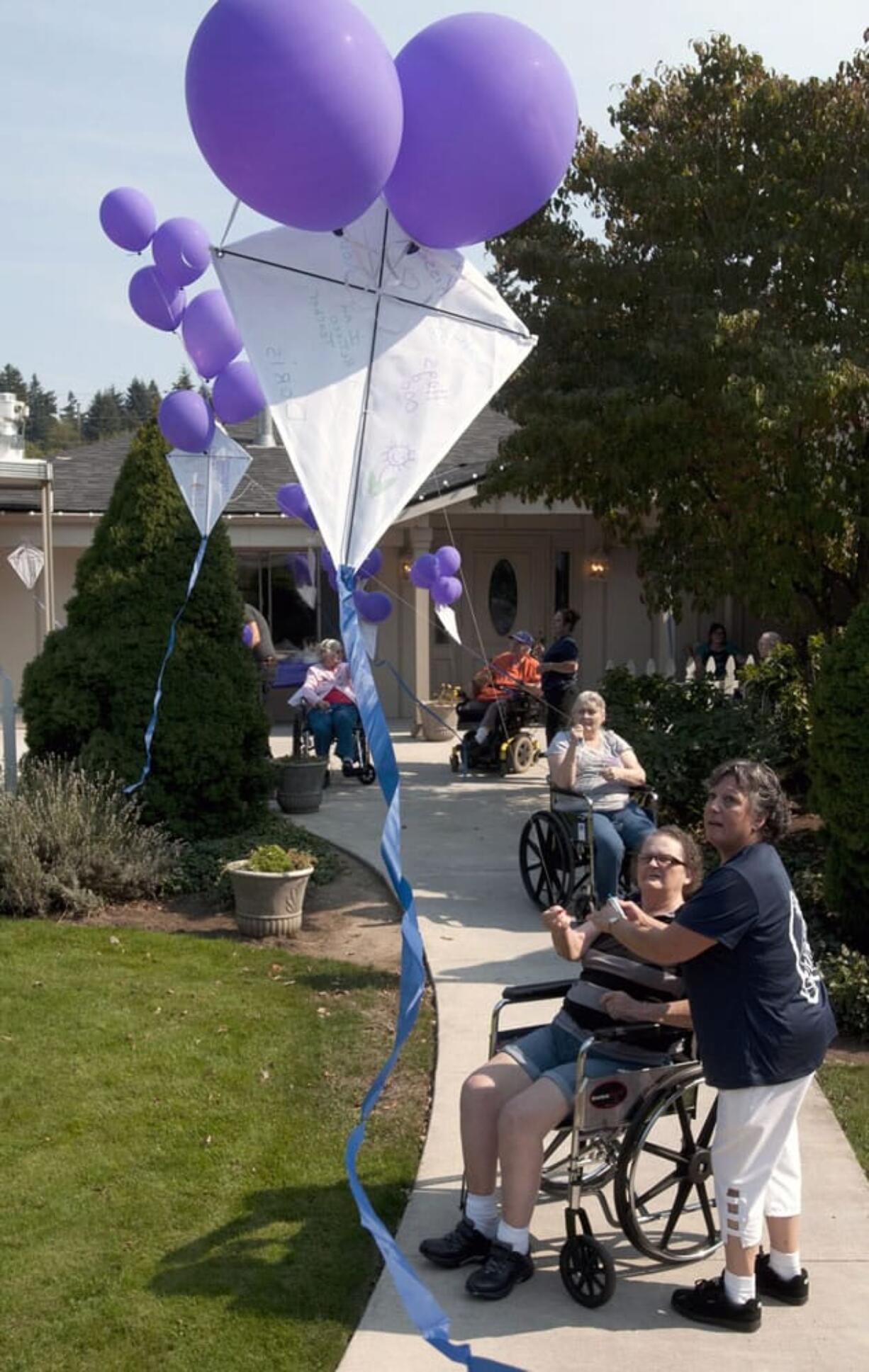 Candy Paasche, foreground, and other Discover Nursing &amp; Rehab residents fly kites with help from Freda Goldfinch, dietary manager, on Sunday afternoon in Hazel Dell.