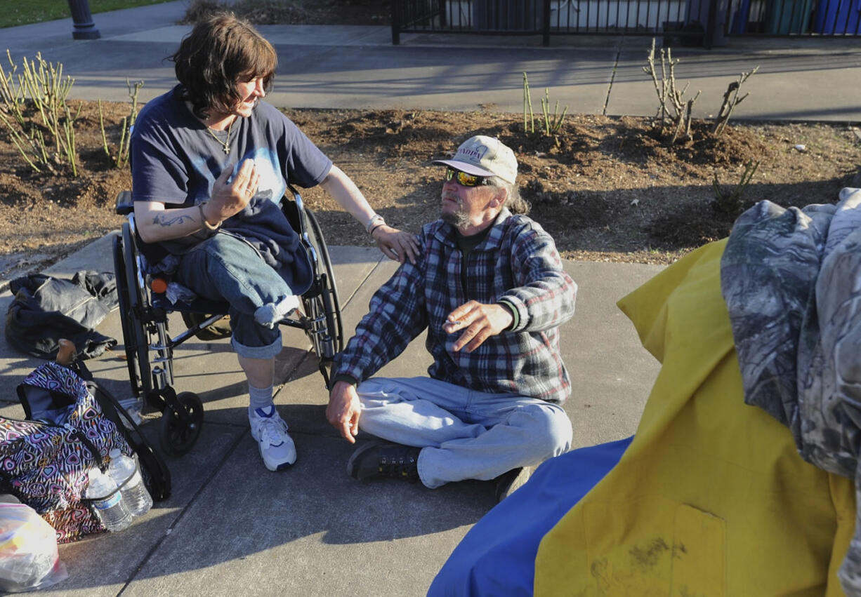 Kelli Jo Barclay, right, and Timothy Smith sit together before they head over for some soup handed out by Hot Soup Vancouver in the gazebo in Esther Short Park in Vancouver on Saturday.